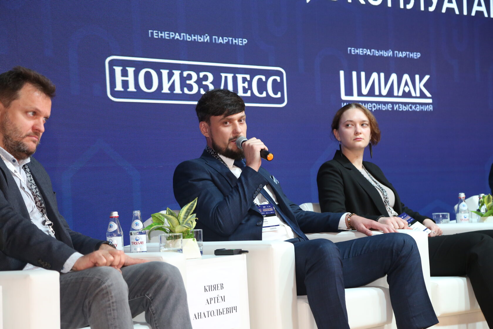 Артём Кияев на панельной дискуссии, на заднике баннеры НОИЗ ЛесС и ЦИИАК, табличка «Кияев Артём Анатольевич»